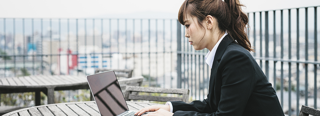 Een vrouw in Kioto, Japan, die buiten op een laptop werkt